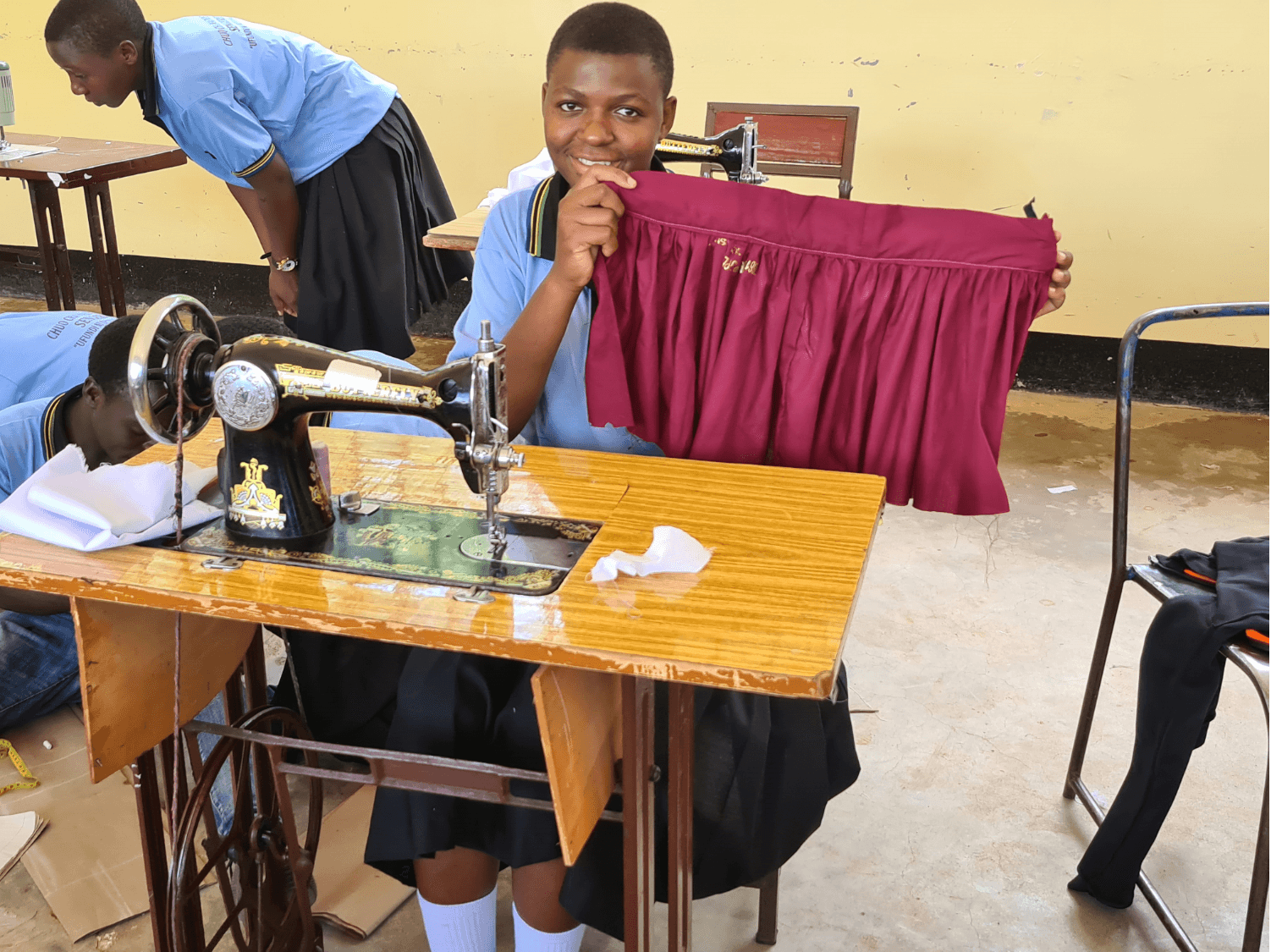 Student displaying finished tailored garment